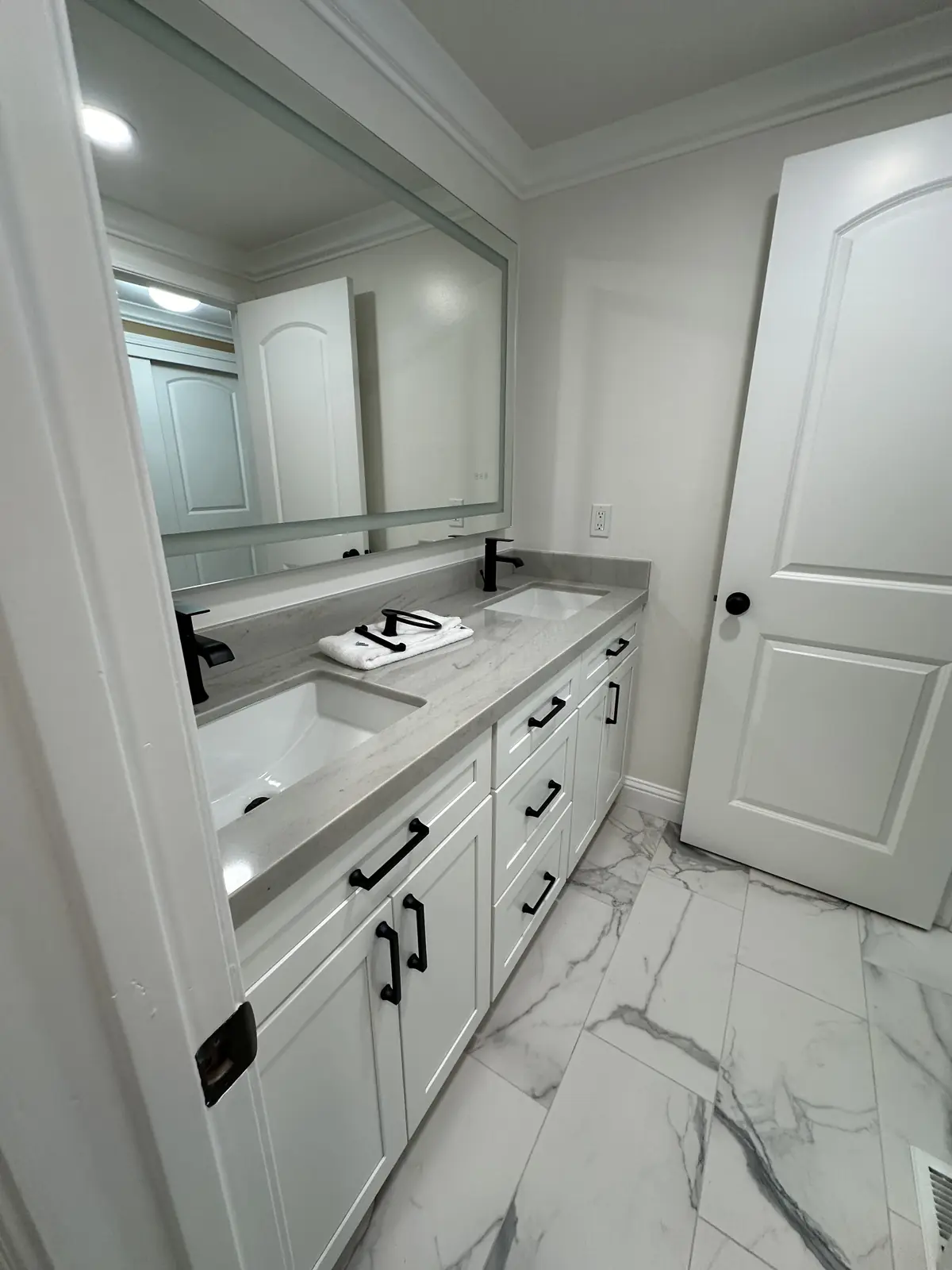 Bathroom with a white double vanity on marble-look tile