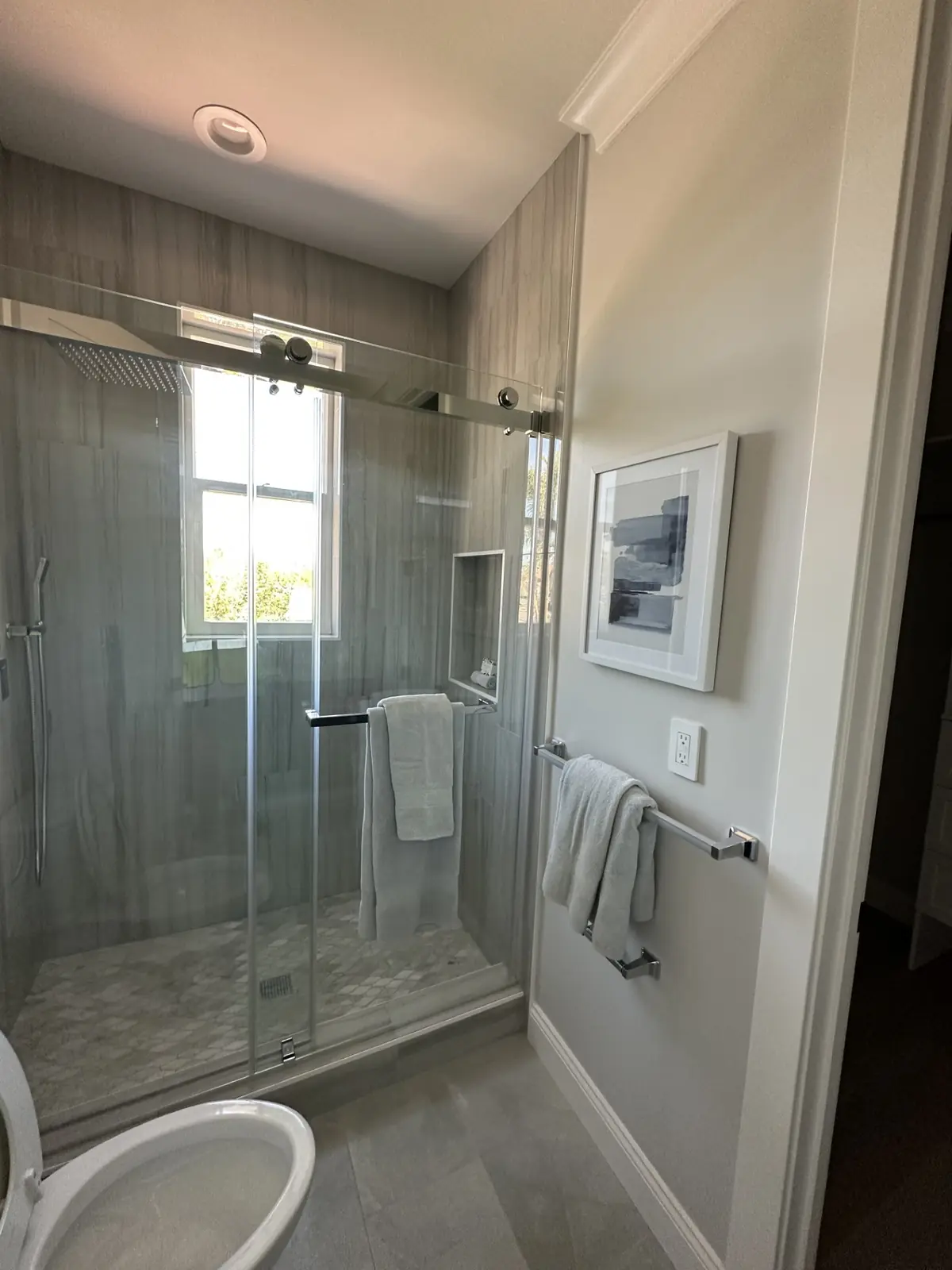 Glass shower with a sliding door and a recessed niche