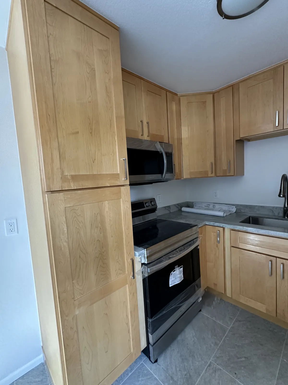 Rebuilt kitchen with maple cabinets and stainless appliances after fire and water damage
