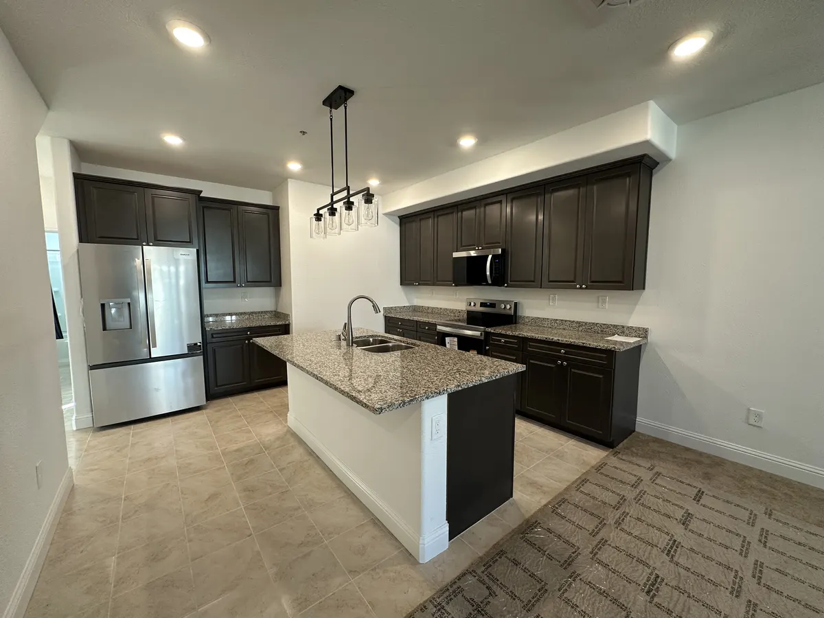 Rebuilt kitchen with dark cabinets and a granite island after fire and water restoration